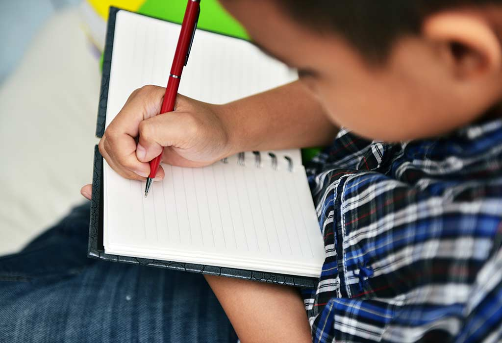 boy writing in notebook