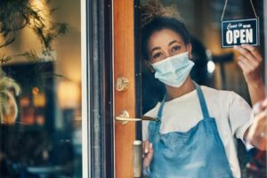 woman in mask at open door